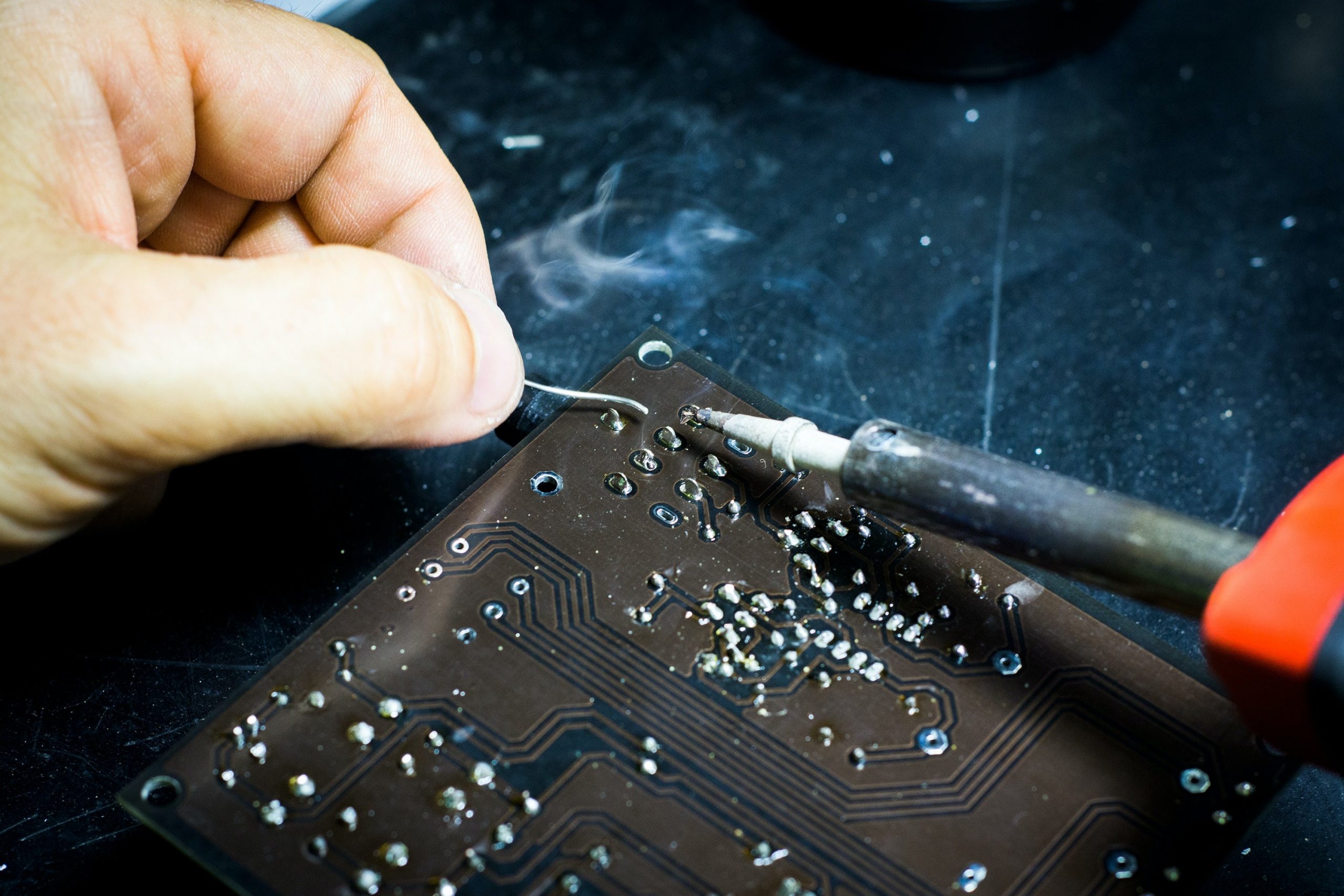 Soldering Tips for Beginners. Close-up of a person soldering electronic components on a PCB board